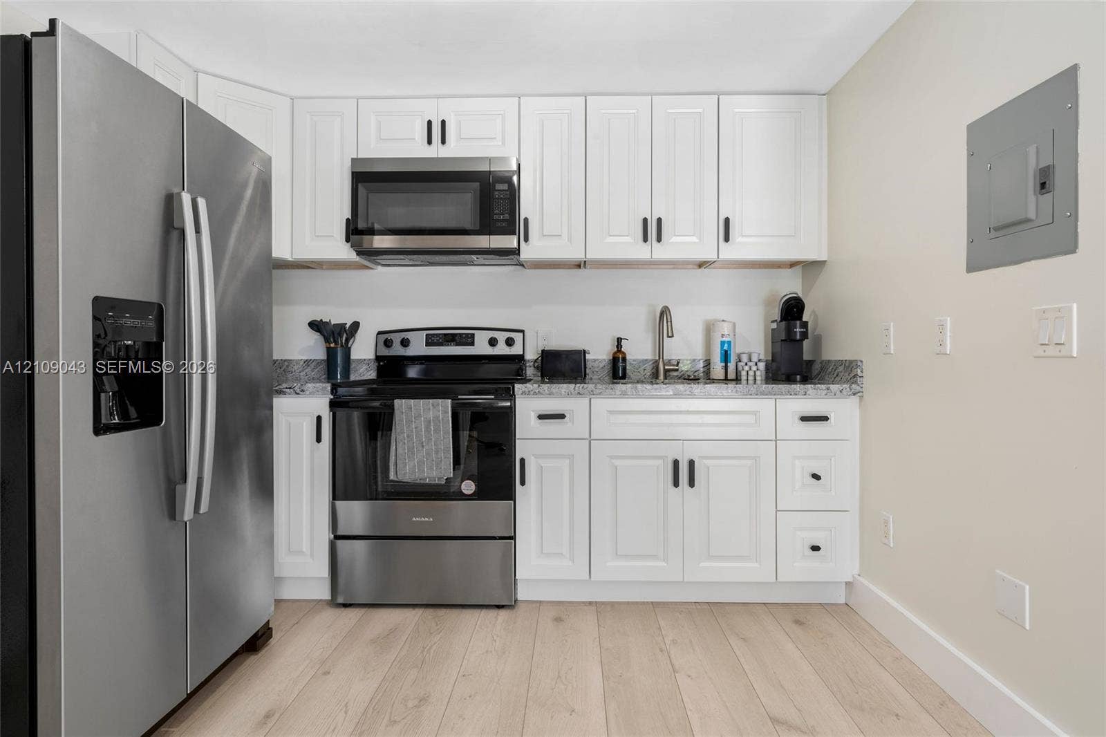 605 SW 17th Street, #1-3, Fort Lauderdale, Fort Lauderdale, FL 33315 Kitchen featuring white shaker-style cabinetry, stainless steel appliances, speckled stone-finish countertops, and wood-finish flooring