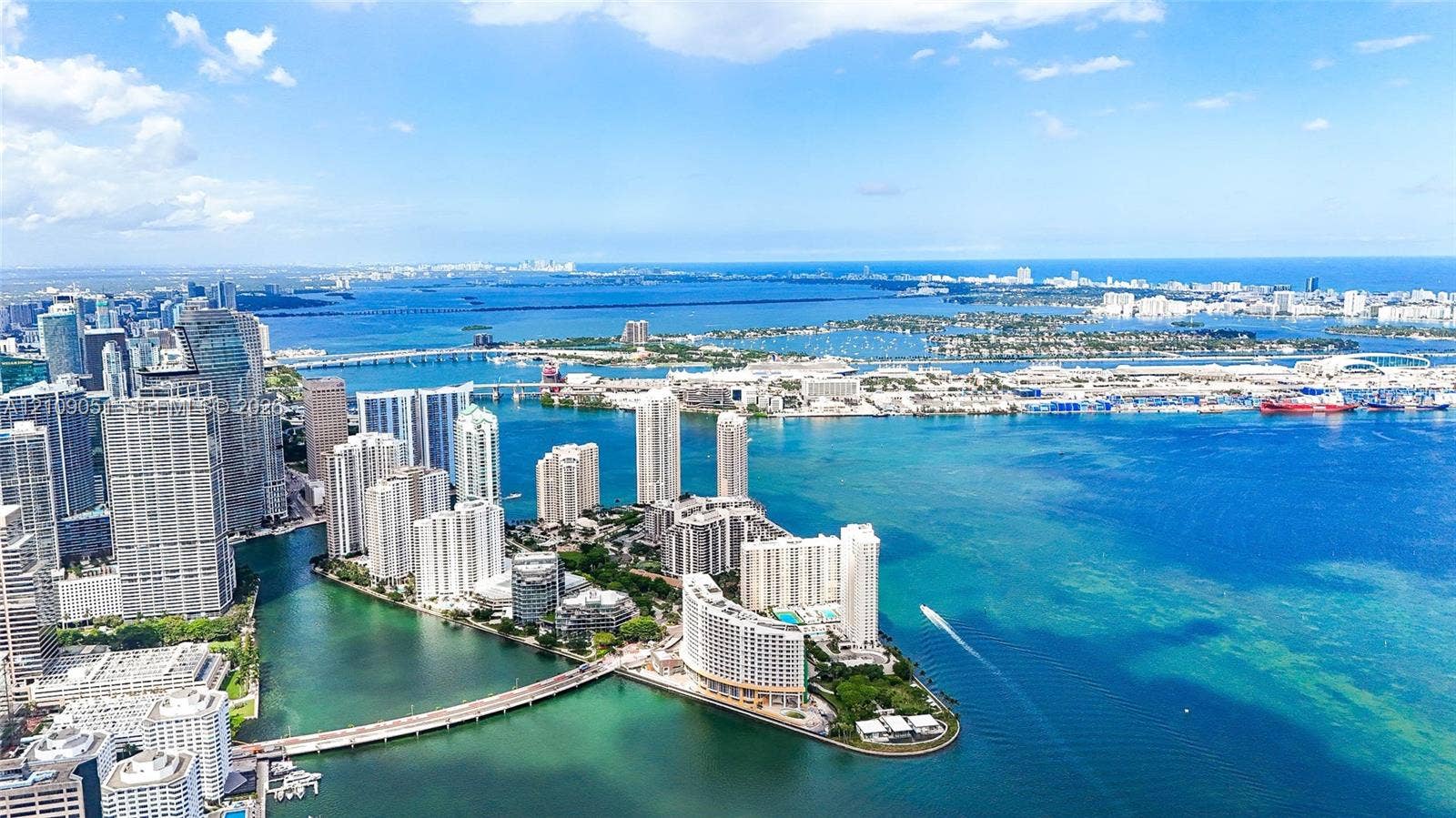 Aerial perspective featuring expansive open water, metropolitan skyline, bridge infrastructure, and coastal peninsula positioning