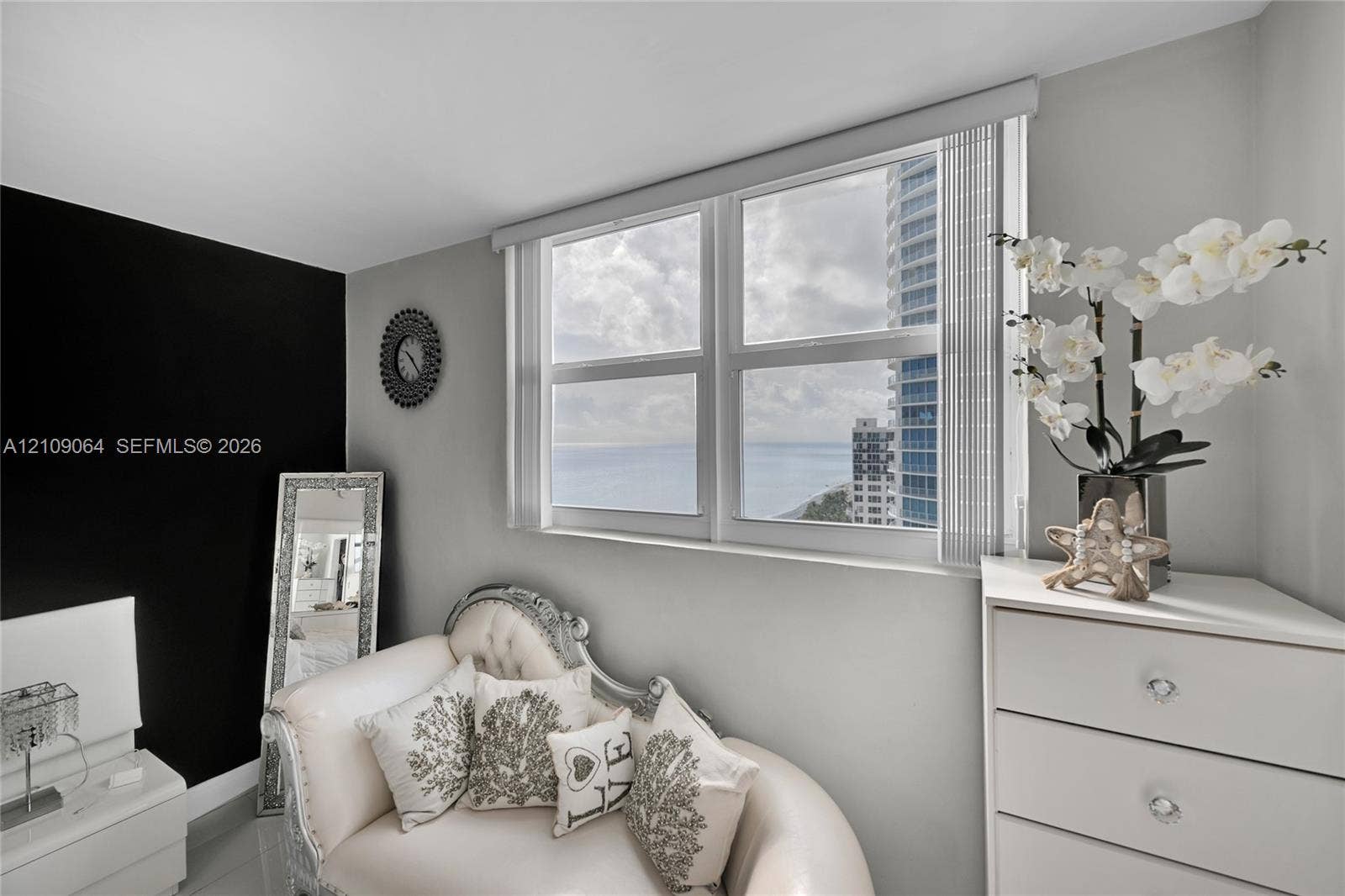 Dual-pane window with vertical blinds, crisp grey wall paint, and bold black accent wall
