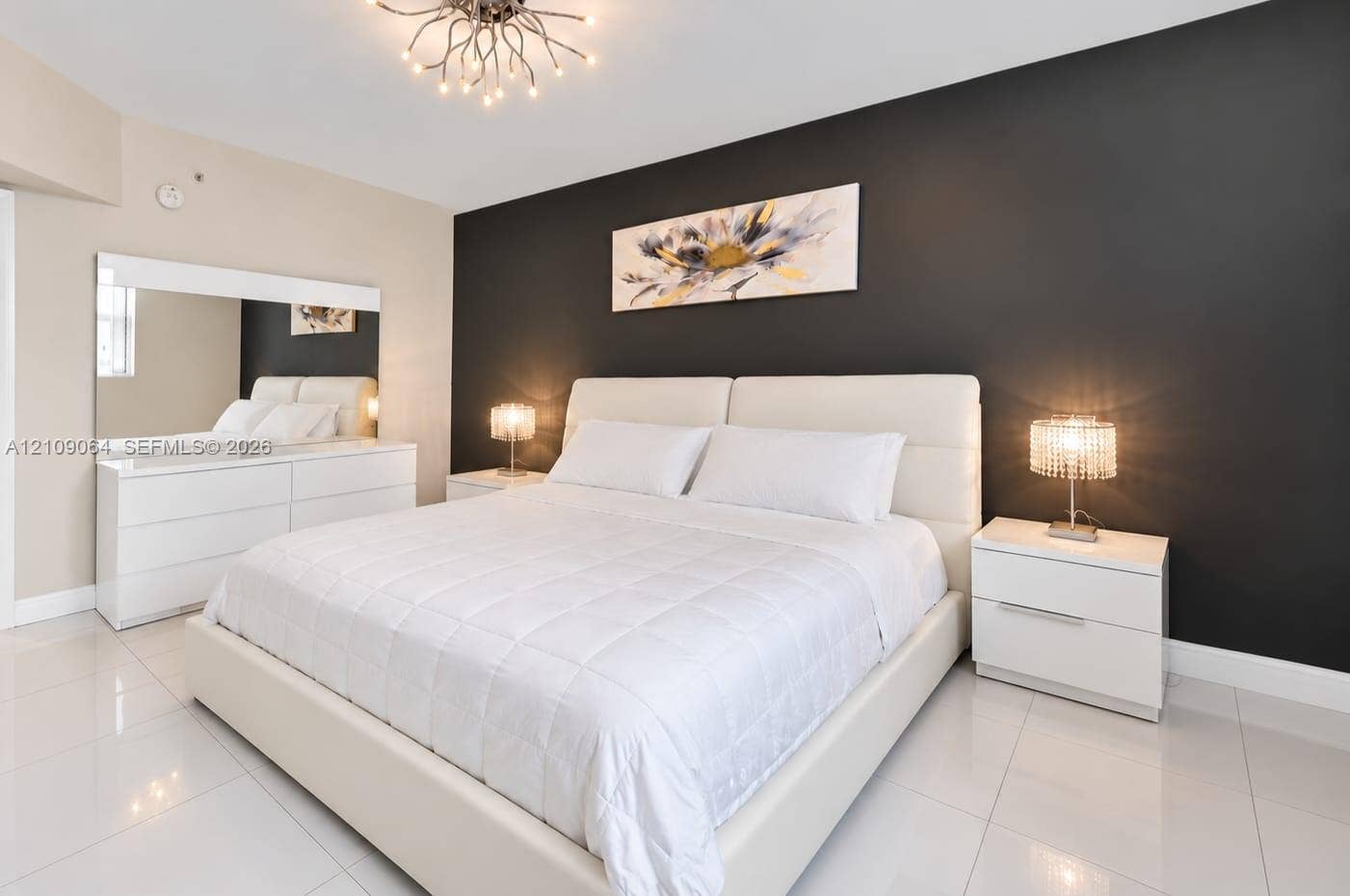 Polished tile flooring, contrast charcoal accent wall, and geometric branch-style chandelier
