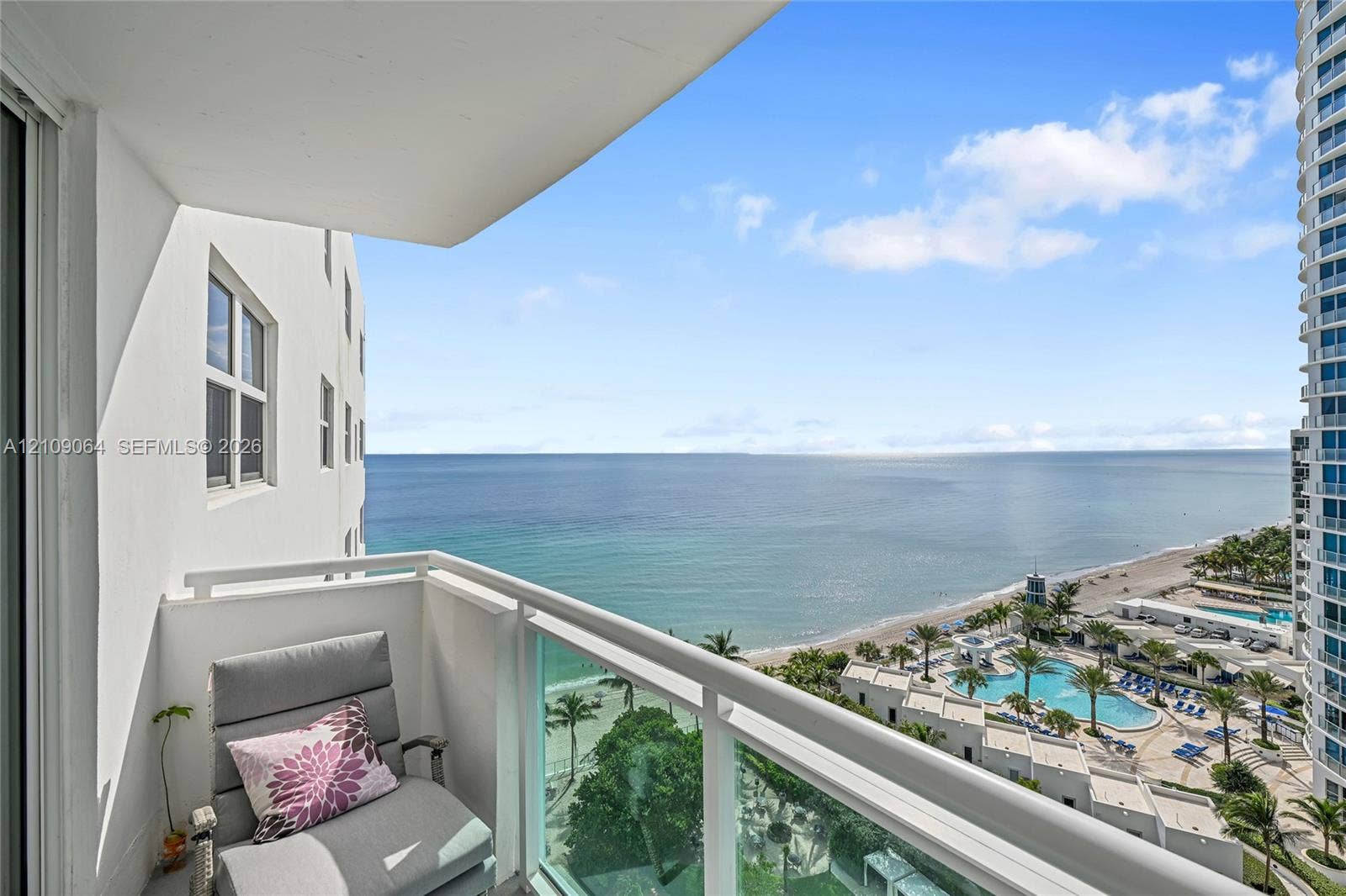 Private balcony featuring a glass-panel railing and expansive ocean scenery
