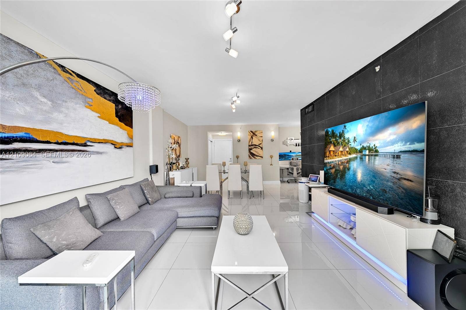 Large format floor tiles, black tiled accent wall, and multi-directional track lighting