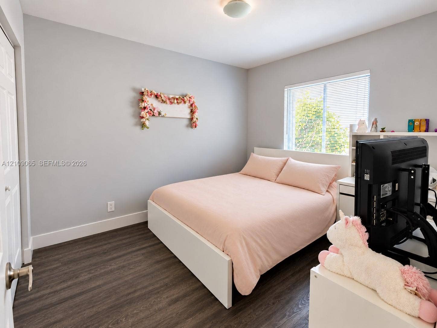Neutral-toned walls, wood-finish flooring, and natural light from a double-pane window