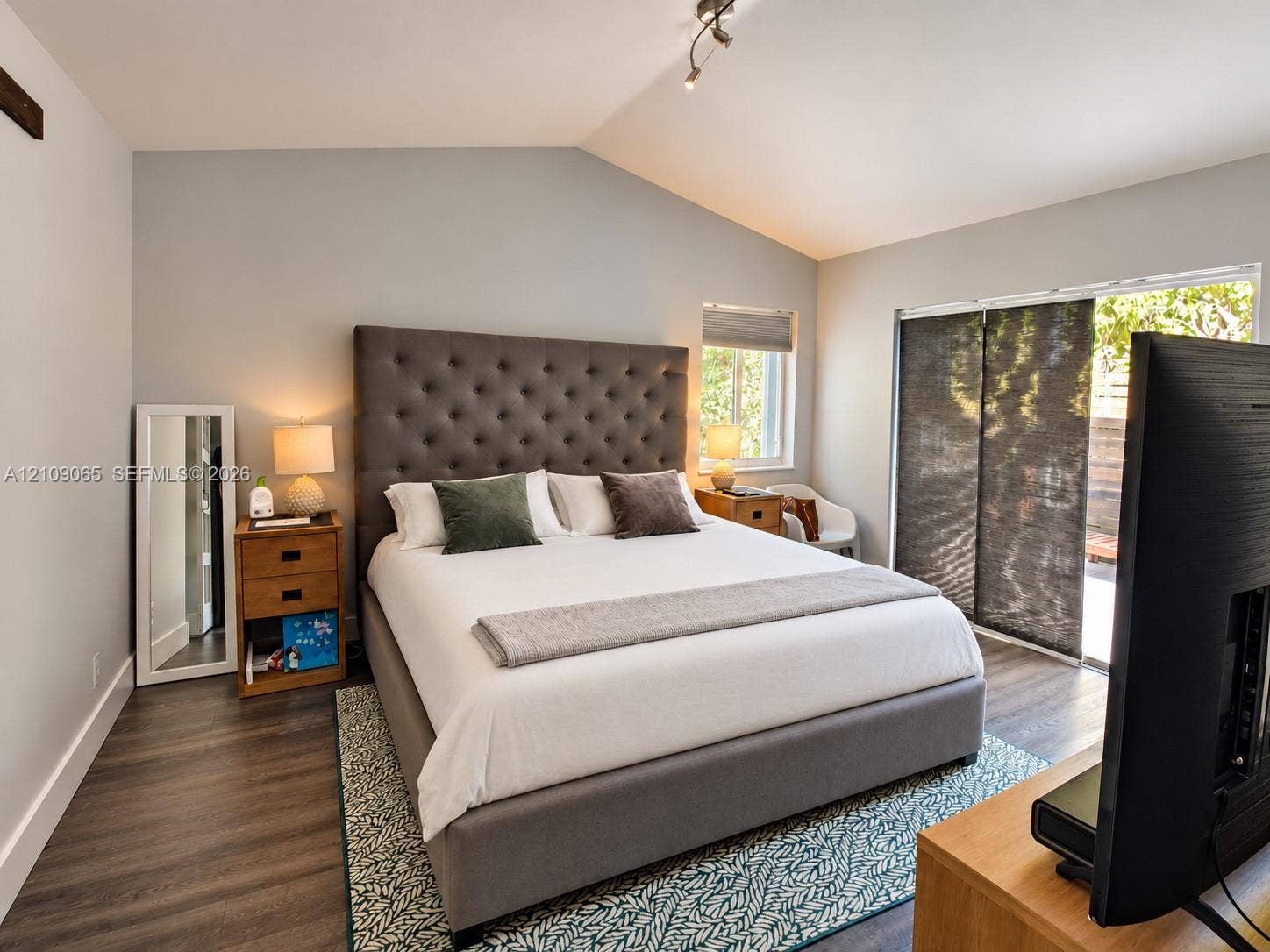 Vaulted ceilings, wood-finish flooring, and sliding glass doors with exterior access
