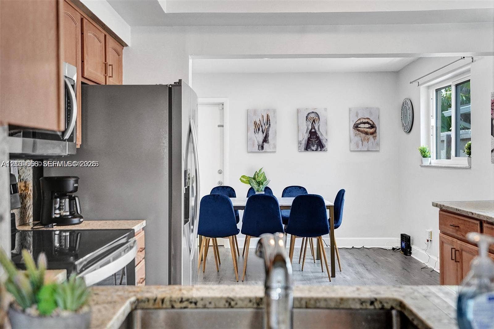 Kitchen featuring wood-finish cabinetry, stainless steel refrigerator, stone countertops, and wood-finish flooring