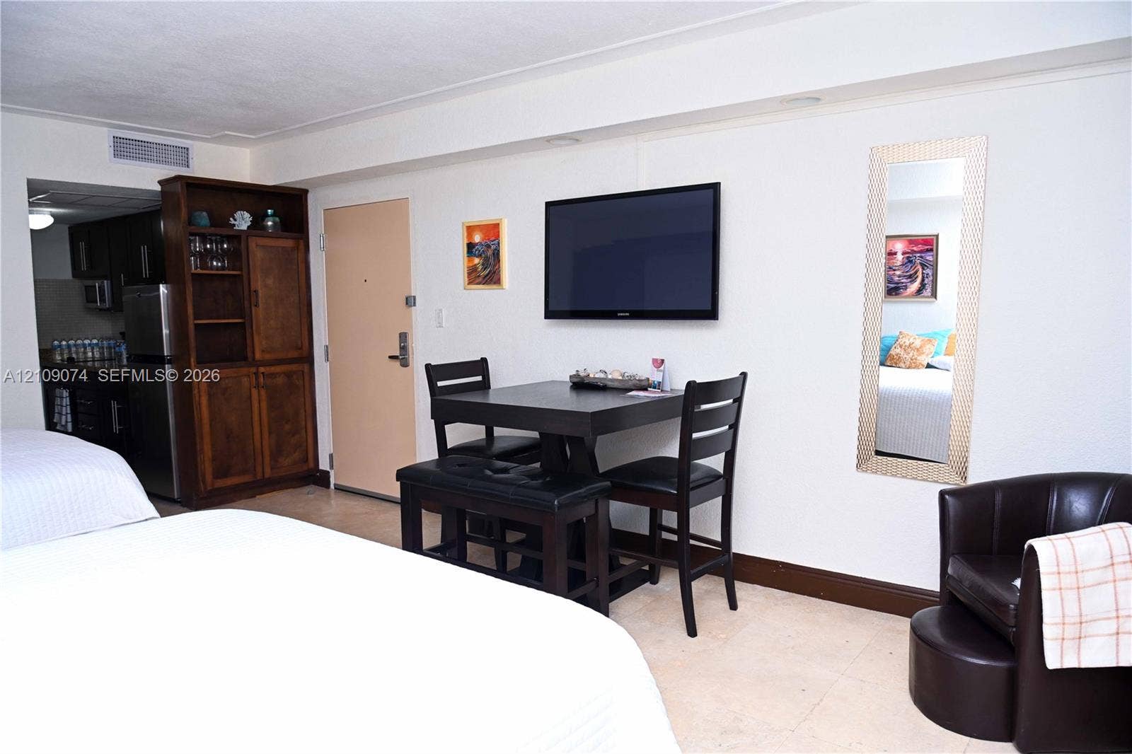 Built-in wood cabinetry, light-toned stone flooring, and a wall-mounted television