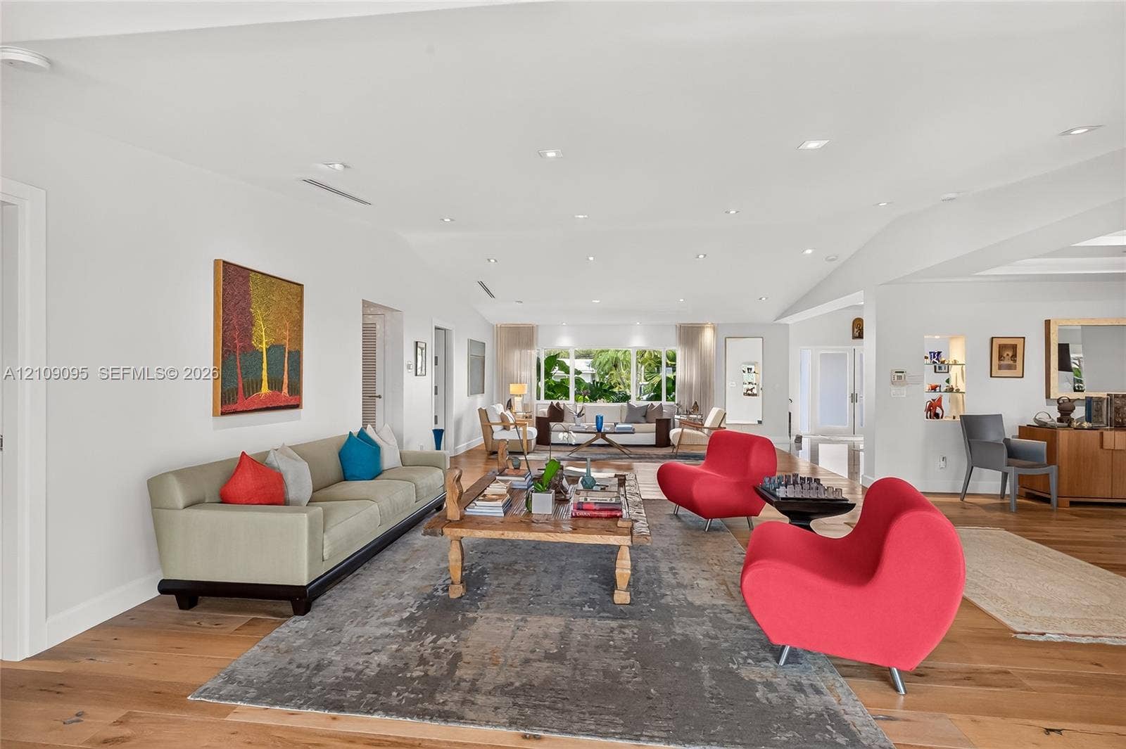 1370 NE 103rd Street, Miami Shores, FL 33138 Wide-plank wood-finish flooring, recessed ceiling lighting, and large paneled windows featuring exterior greenery