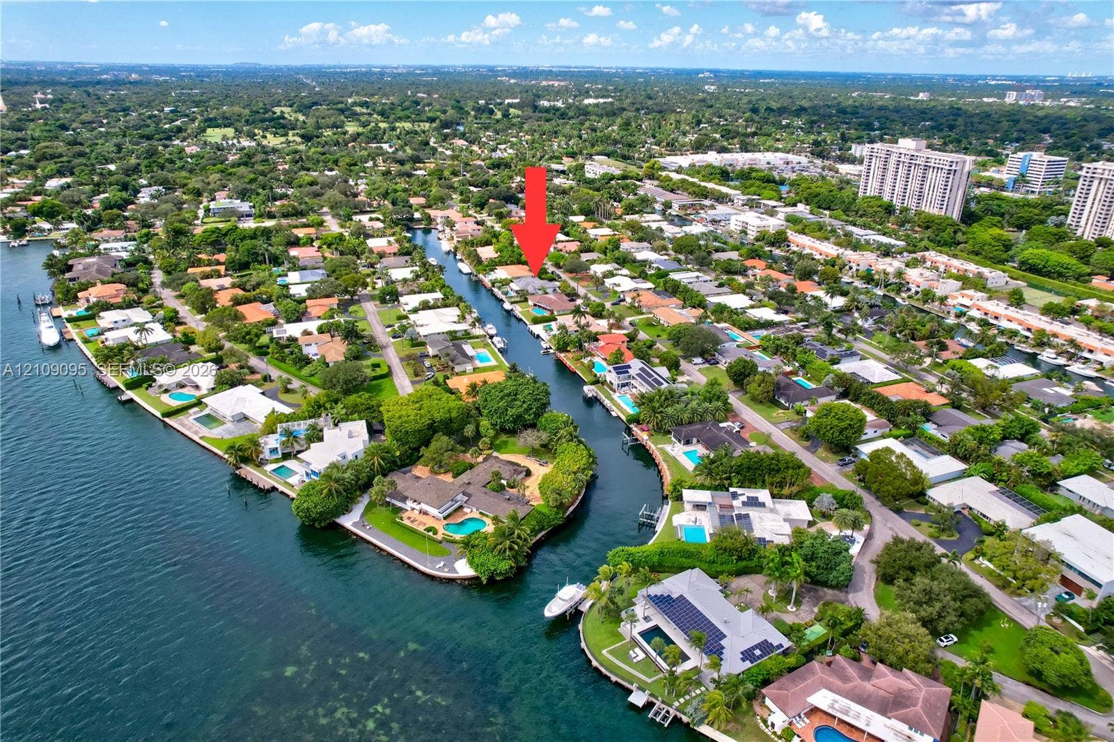1370 NE 103rd Street, Miami Shores, FL 33138 Aerial perspective of a canal-front property featuring direct water access, a private bulkhead, and mature tropical landscaping