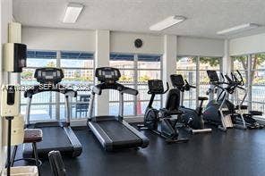 Fitness center featuring floor-to-ceiling windows, rubberized flooring, and built-in wall-mounted soap and sanitizer dispensers