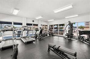 Fitness facility featuring extensive floor-to-ceiling windows, recessed rectangular lighting, and durable rubberized flooring