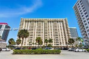 High-rise residential exterior featuring expansive private balconies and mature palm tree landscaping