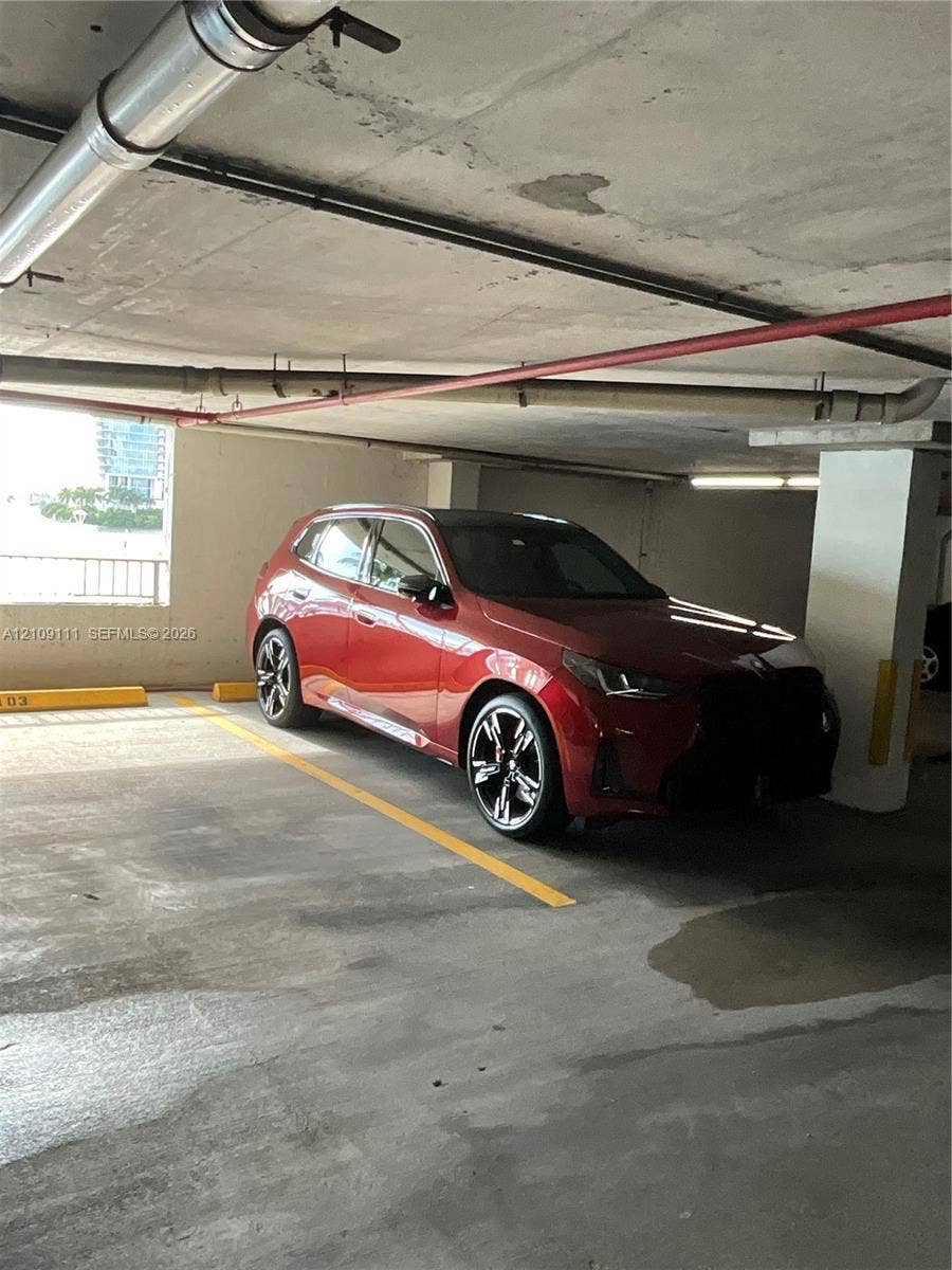 3370 Hidden Bay Drive, #801, Aventura, FL 33180 Covered parking structure featuring concrete flooring, structural support columns, and overhead utility piping