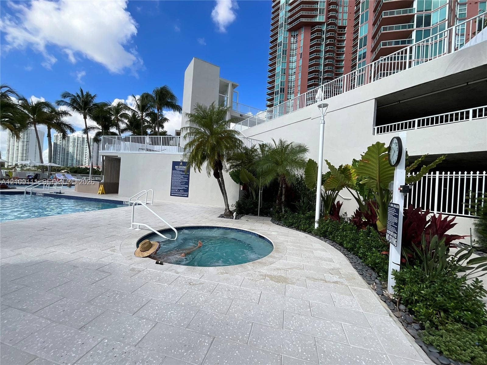 3370 Hidden Bay Drive, #801, Aventura, FL 33180 In-ground hot tub featuring stone tile surround, swimming pool, and tropical landscaping