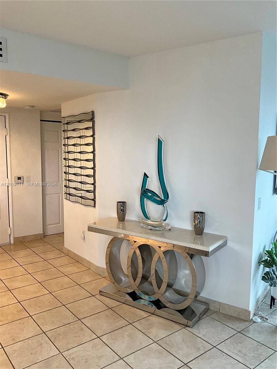 3370 Hidden Bay Drive, #801, Aventura, FL 33180 Neutral-toned tile flooring and wall-mounted decorative mirrored glass panel