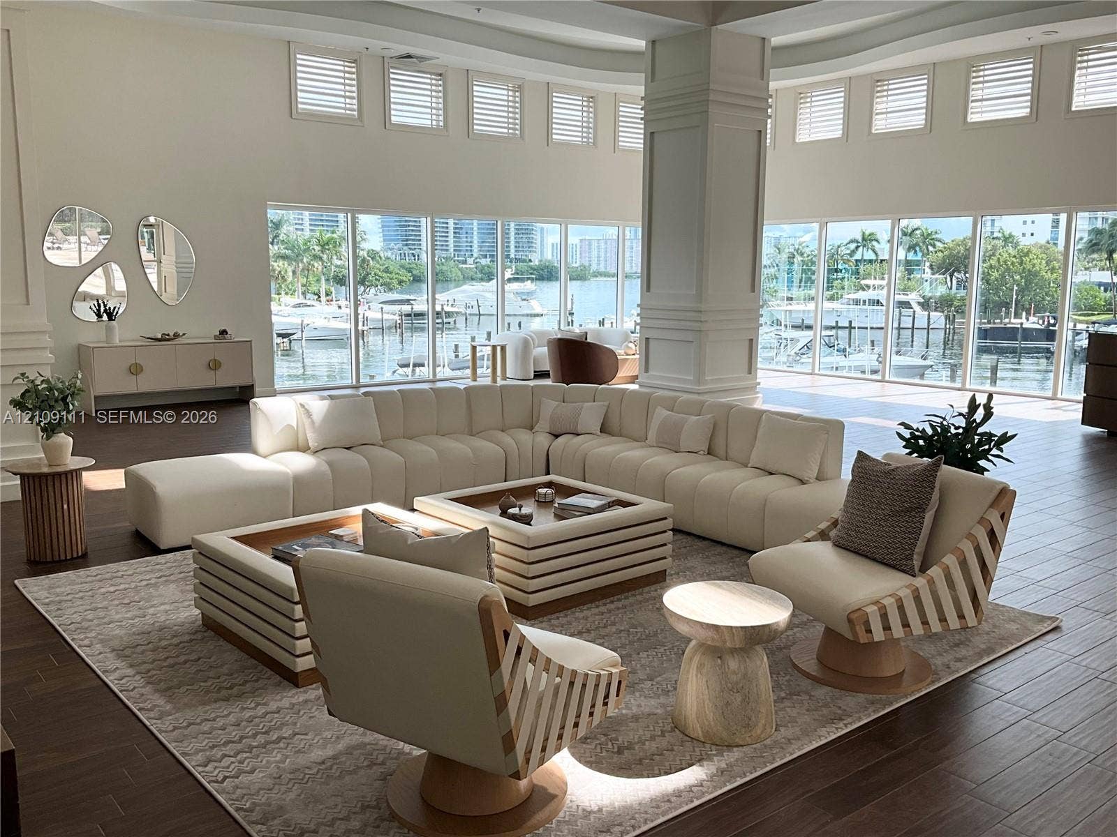 3370 Hidden Bay Drive, #801, Aventura, FL 33180 Expansive living area featuring floor-to-ceiling windows, dark wood-finish flooring, soaring ceilings, and a central architectural pillar