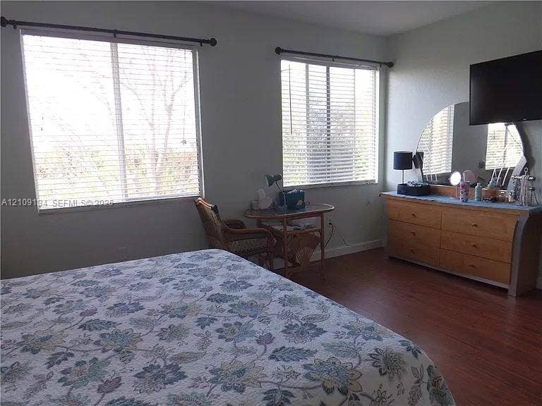 2529 SW Stockbridge Square SW, Vero Beach, FL 32962 Room featuring wood-finish flooring and two large windows with horizontal blinds