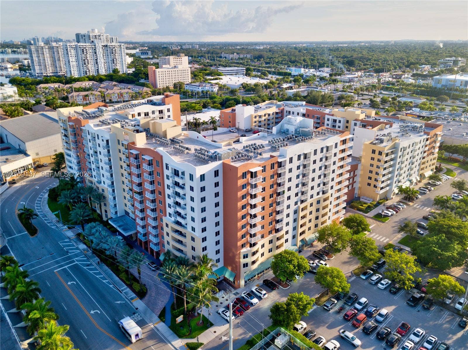 18800 NE 29th Avenue, #411, Aventura, FL 33180 Multi-story mid-rise structure featuring a stucco exterior, private balconies, and a dedicated surface parking area
