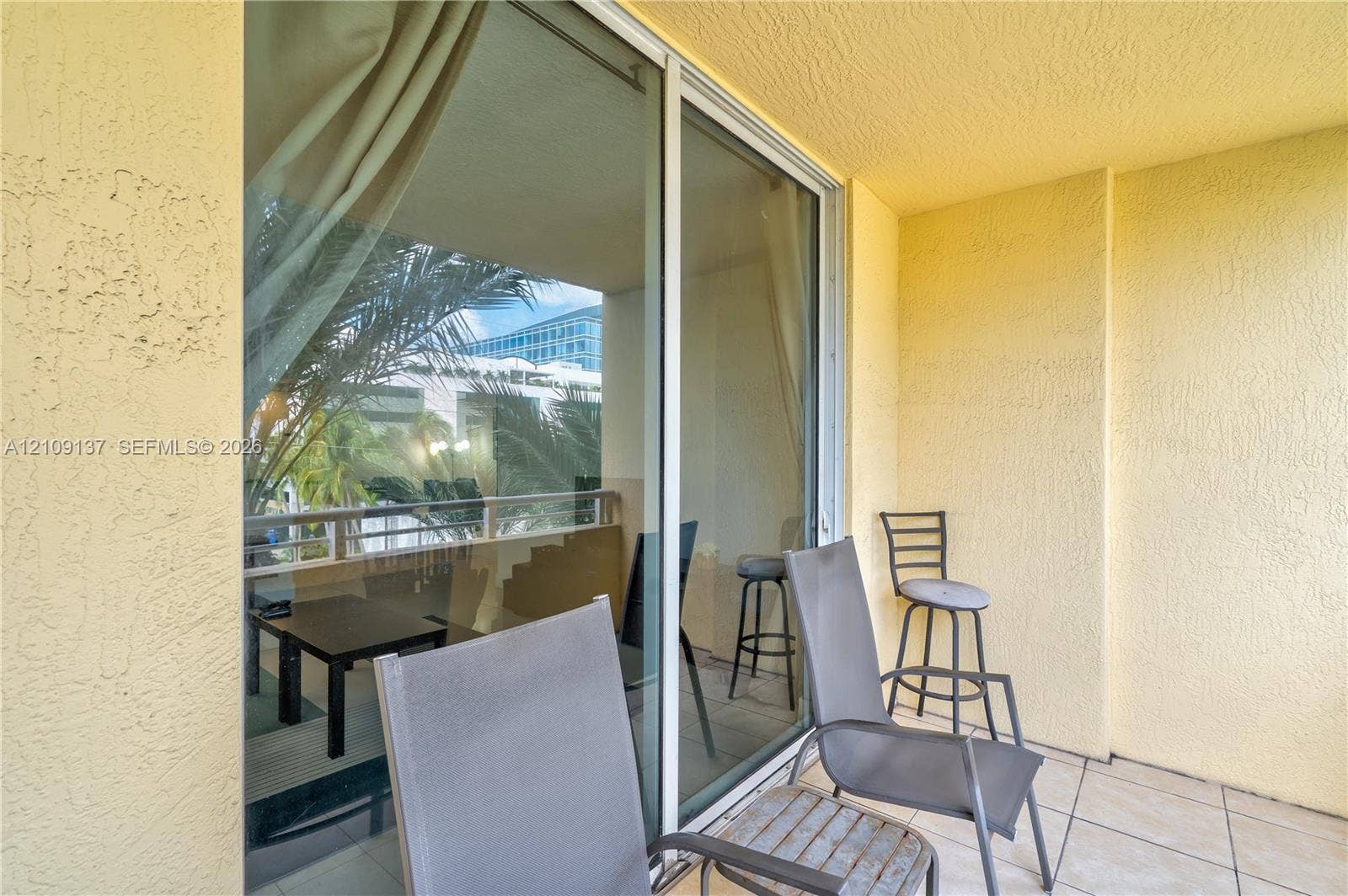 18800 NE 29th Avenue, #411, Aventura, FL 33180 Private balcony with tile flooring, stucco wall finish, and sliding glass door entry