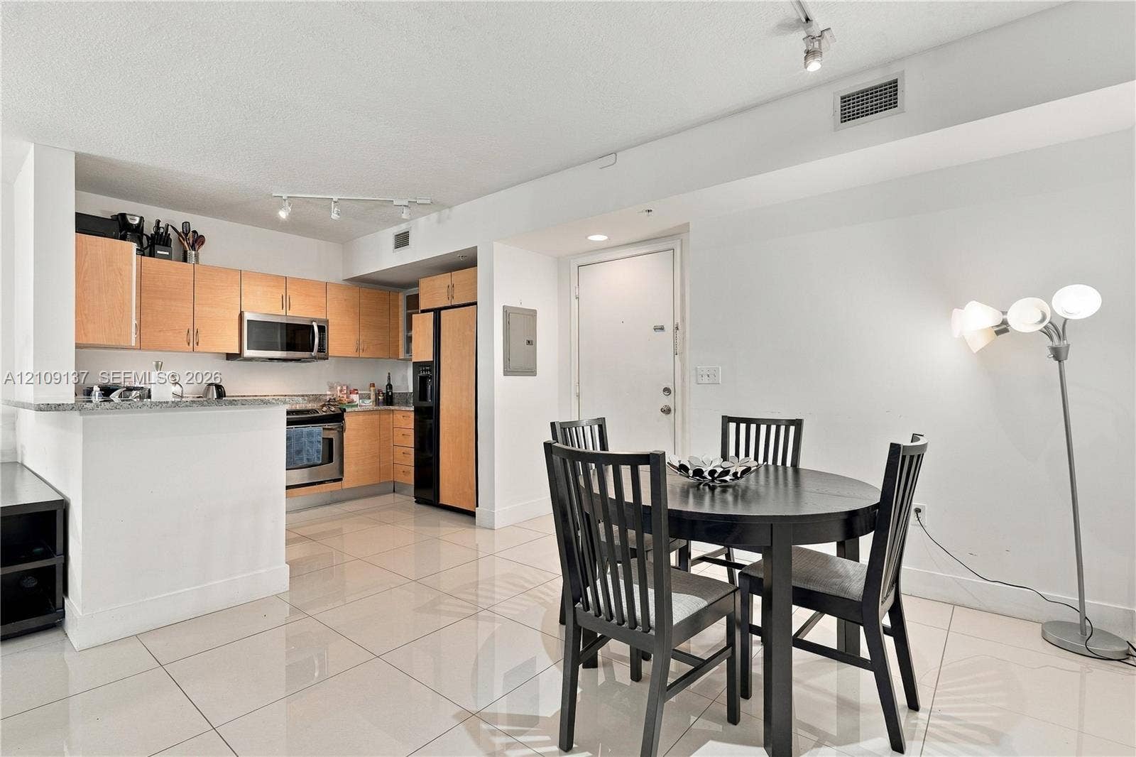 18800 NE 29th Avenue, #411, Aventura, FL 33180 Kitchen featuring flat-panel wood cabinetry, stone countertops, stainless steel appliances, and large-format tile flooring