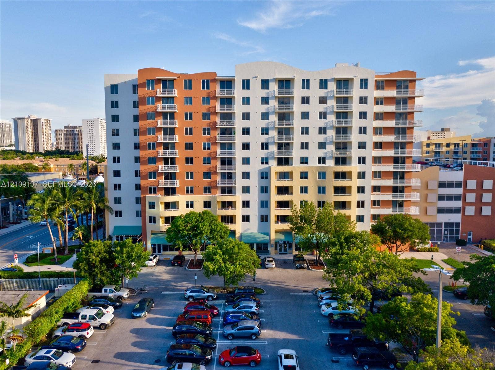 18800 NE 29th Avenue, #411, Aventura, FL 33180 Multi-story residential building featuring a stucco exterior, private balconies, and dedicated surface parking