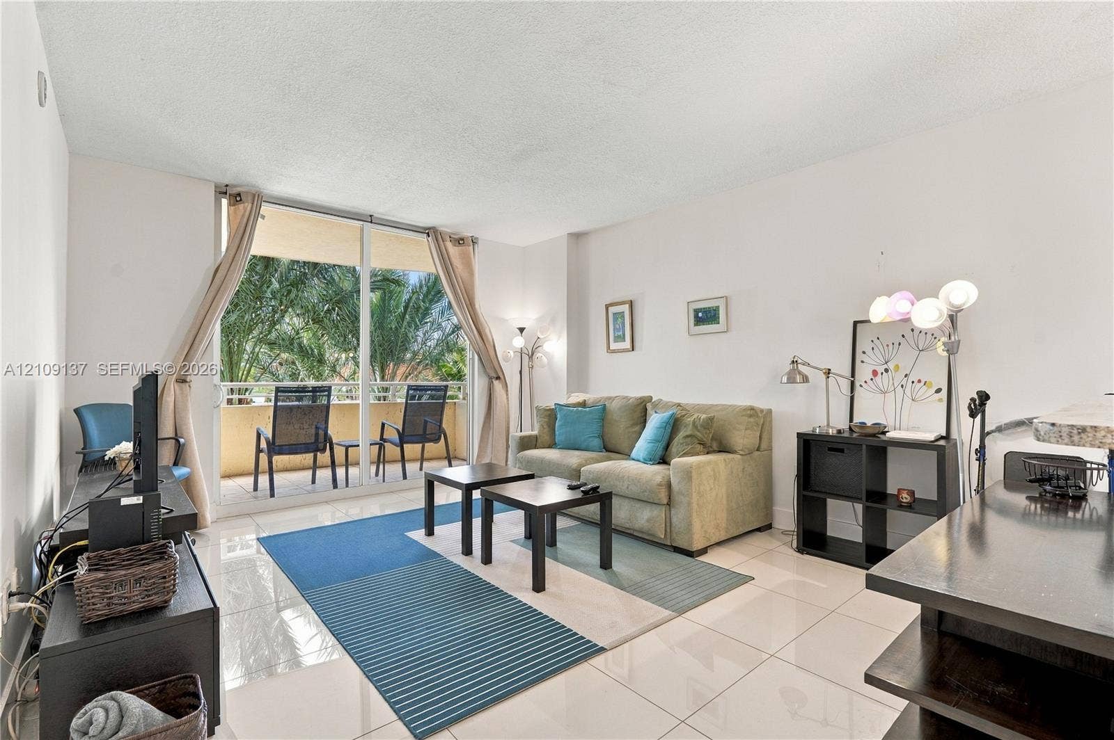 18800 NE 29th Avenue, #411, Aventura, FL 33180 Living space featuring large-format tile flooring, oversized floor-to-ceiling glass sliding doors, and a private balcony