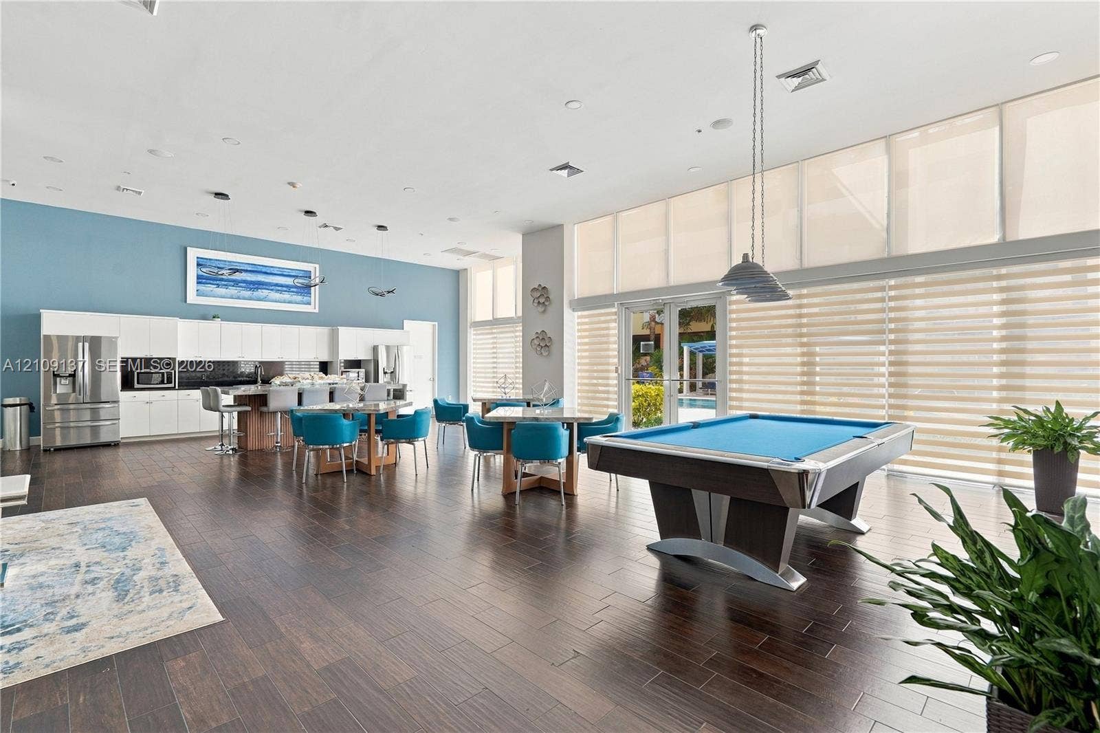 18800 NE 29th Avenue, #411, Aventura, FL 33180 Open-concept room featuring wood-finish flooring, floor-to-ceiling windows, built-in cabinetry, recessed lighting, and suspended multi-light fixtures
