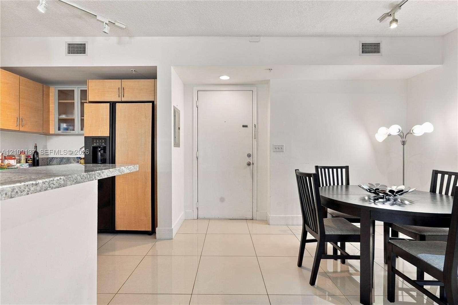 18800 NE 29th Avenue, #411, Aventura, FL 33180 Kitchen featuring light-finish cabinetry, stone-patterned countertops, a breakfast bar, and tile flooring with track lighting