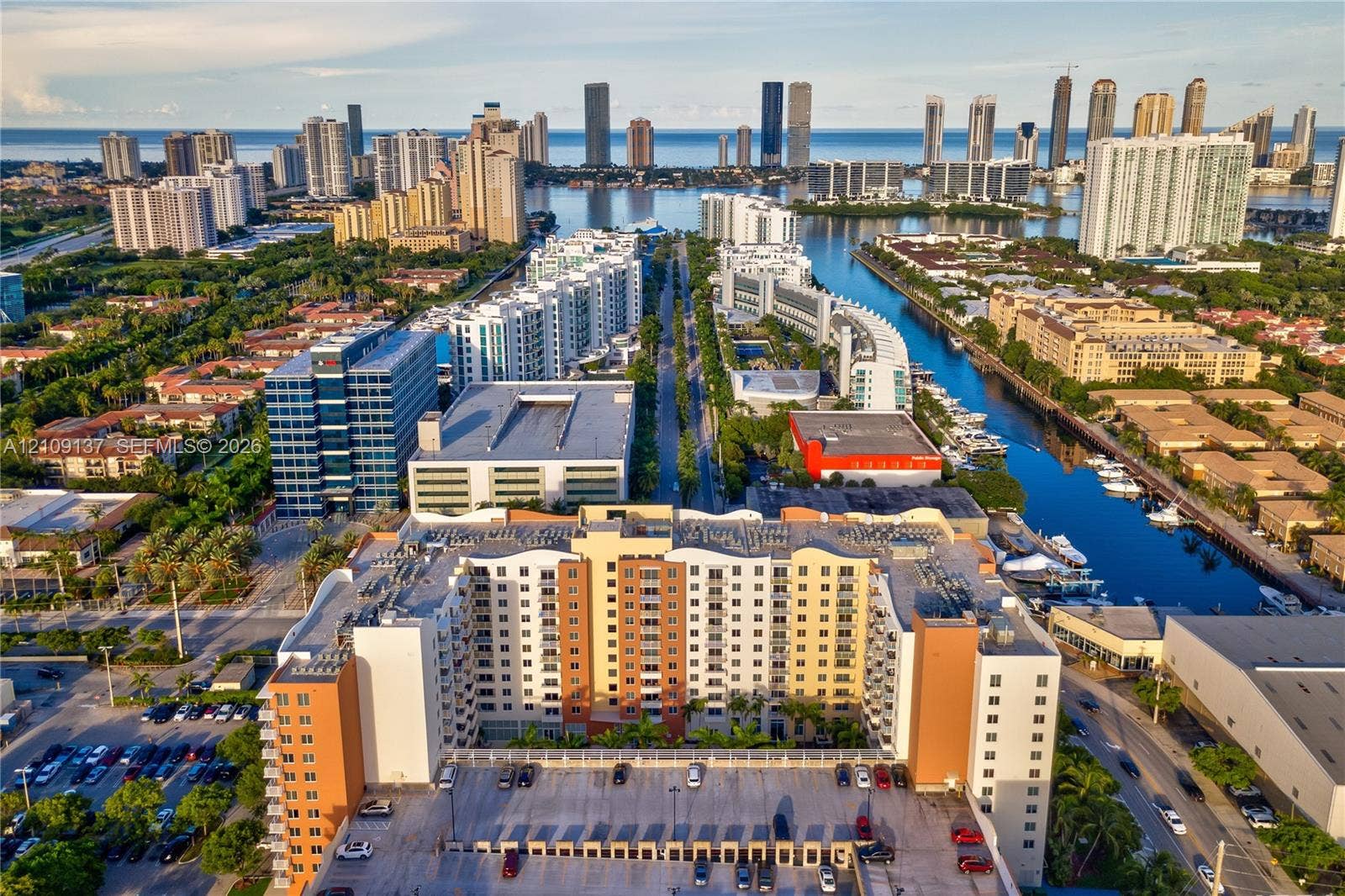 18800 NE 29th Avenue, #411, Aventura, FL 33180 Multi-story high-rise building featuring a structured parking facility, concrete facade, and integrated balconies