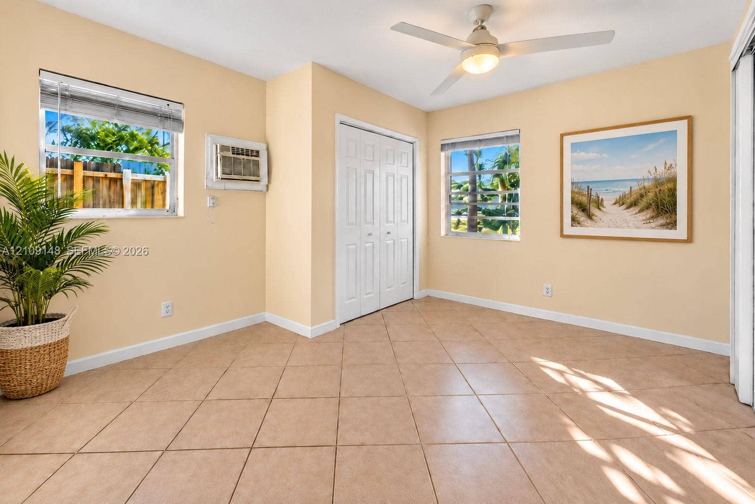1701 SW 23rd Avenue, Fort Lauderdale, FL 33312 Interior space featuring tile flooring, dual-pane windows, a white ceiling fan with integrated lighting, and a closet with bifold doors