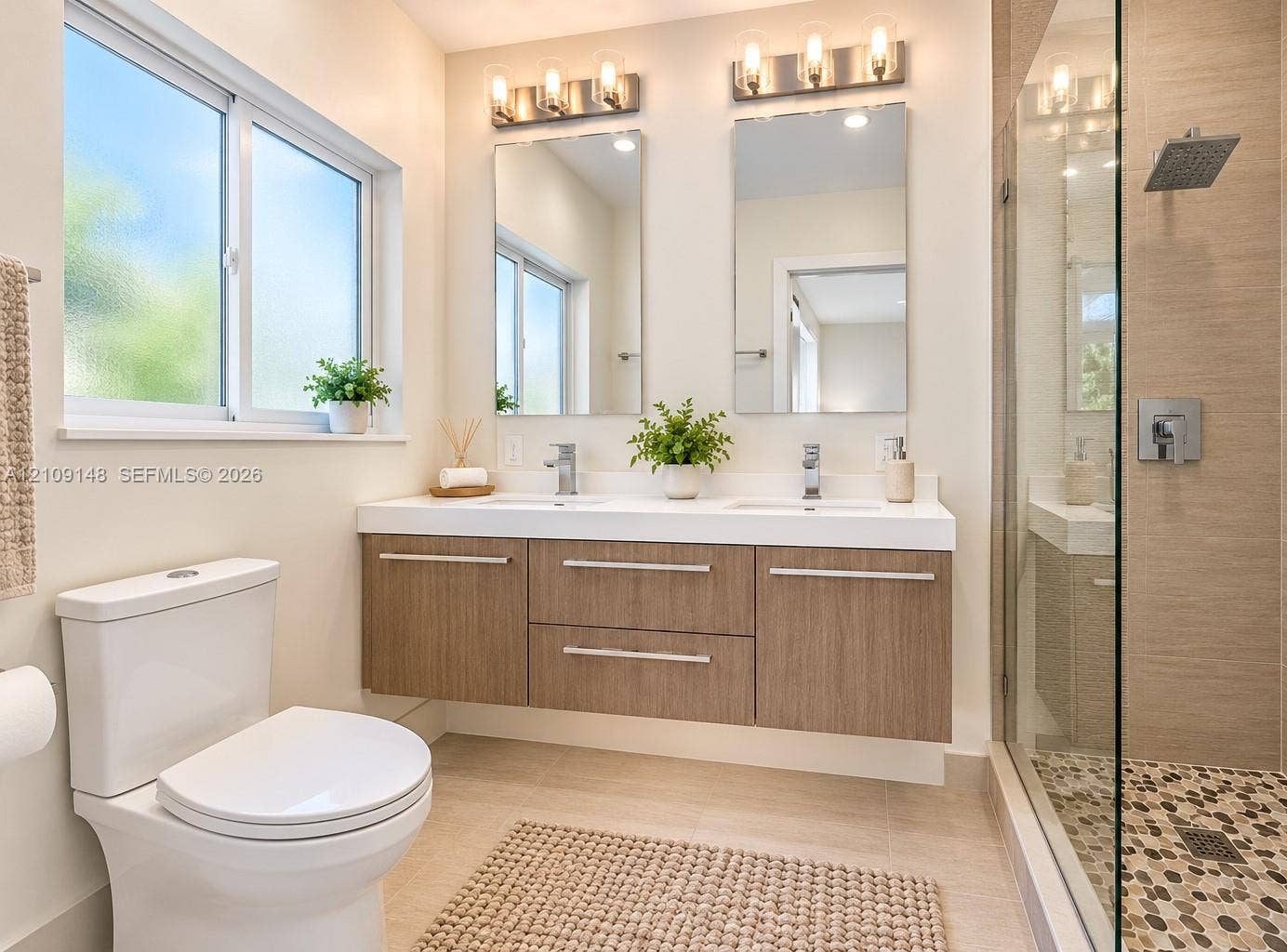1701 SW 23rd Avenue, Fort Lauderdale, FL 33312 Floating dual-sink vanity with wood-finish cabinetry, quartz countertop, glass-enclosed shower with pebble tile flooring, and wall-mounted light fixtures