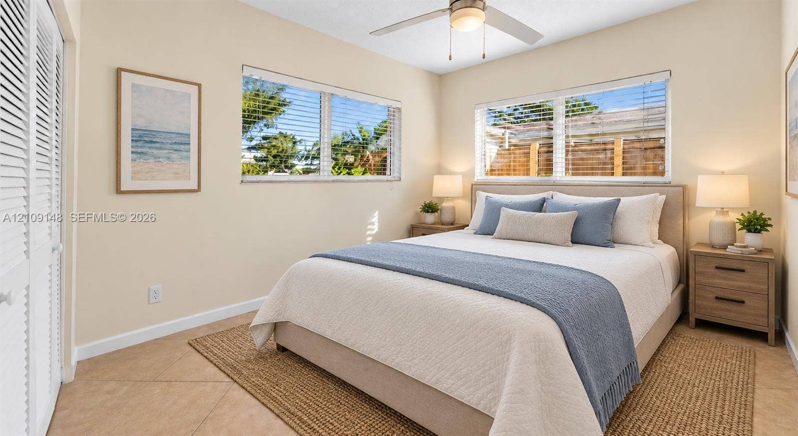 1701 SW 23rd Avenue, Fort Lauderdale, FL 33312 Neutral-toned walls, tile flooring, dual windows with horizontal blinds, built-in louvered closet doors, and ceiling fan with integrated light fixture