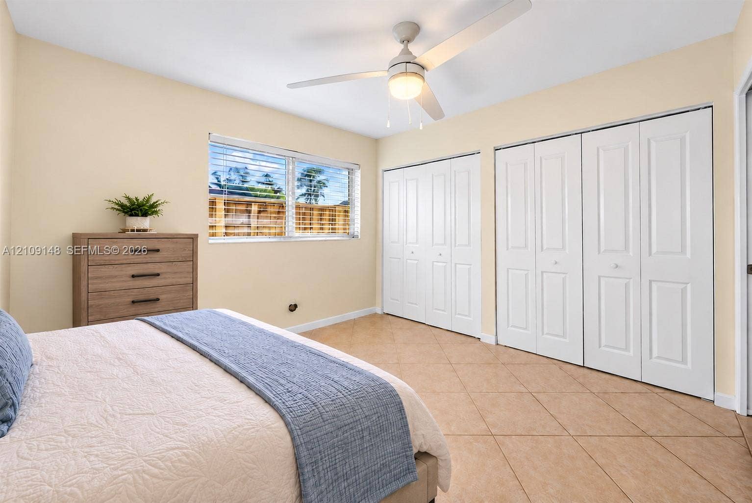 1701 SW 23rd Avenue, Fort Lauderdale, FL 33312 Room featuring tile flooring, dual sets of bi-fold closet doors, a central ceiling fan with an integrated light fixture, and horizontal-sliding windows