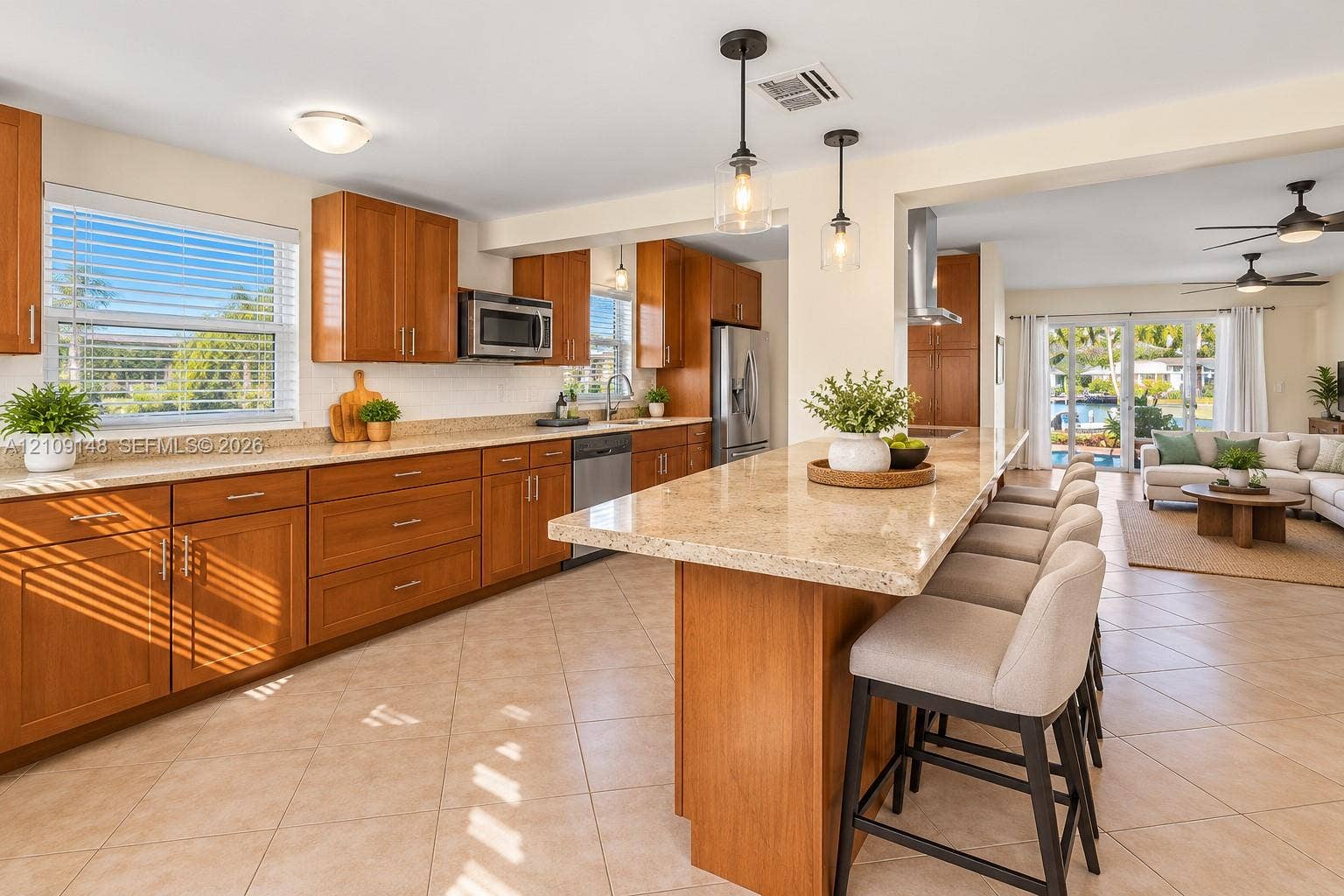 1701 SW 23rd Avenue, Fort Lauderdale, FL 33312 Kitchen featuring shaker-style wood cabinetry, stone countertops, a large center island with breakfast bar seating, stainless steel appliances, and tile flooring