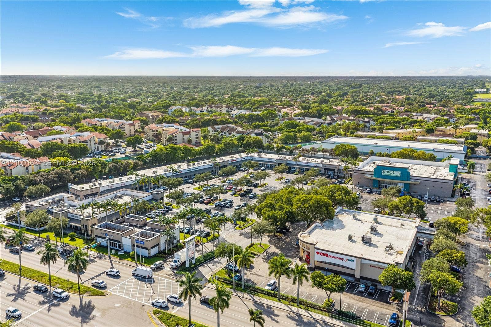 9122 SW 127th Avenue, Miami, FL 33186 Commercial shopping center featuring multiple storefronts, an integrated parking lot, palm tree landscaping, and prominent street frontage