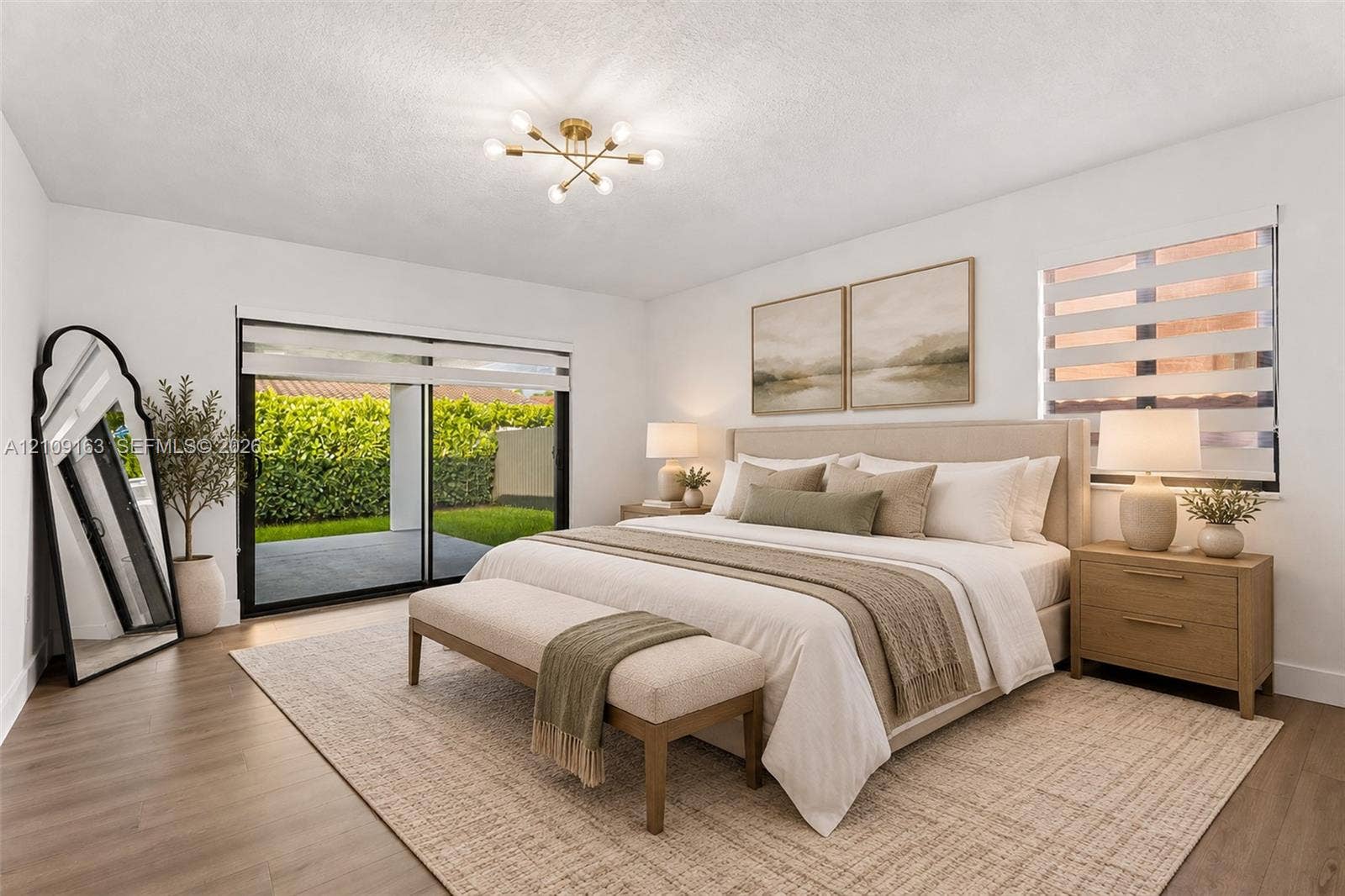 9122 SW 127th Avenue, Miami, FL 33186 Neutral-toned room featuring wood-finish flooring, sliding glass door with external access, multi-light modern ceiling fixture, and dual windows equipped with horizontal blinds