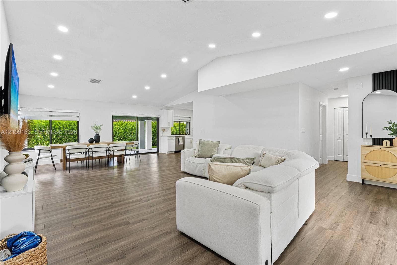 9122 SW 127th Avenue, Miami, FL 33186 Open-concept living space featuring high vaulted ceilings, recessed lighting, wood-finish flooring, and large sliding glass doors