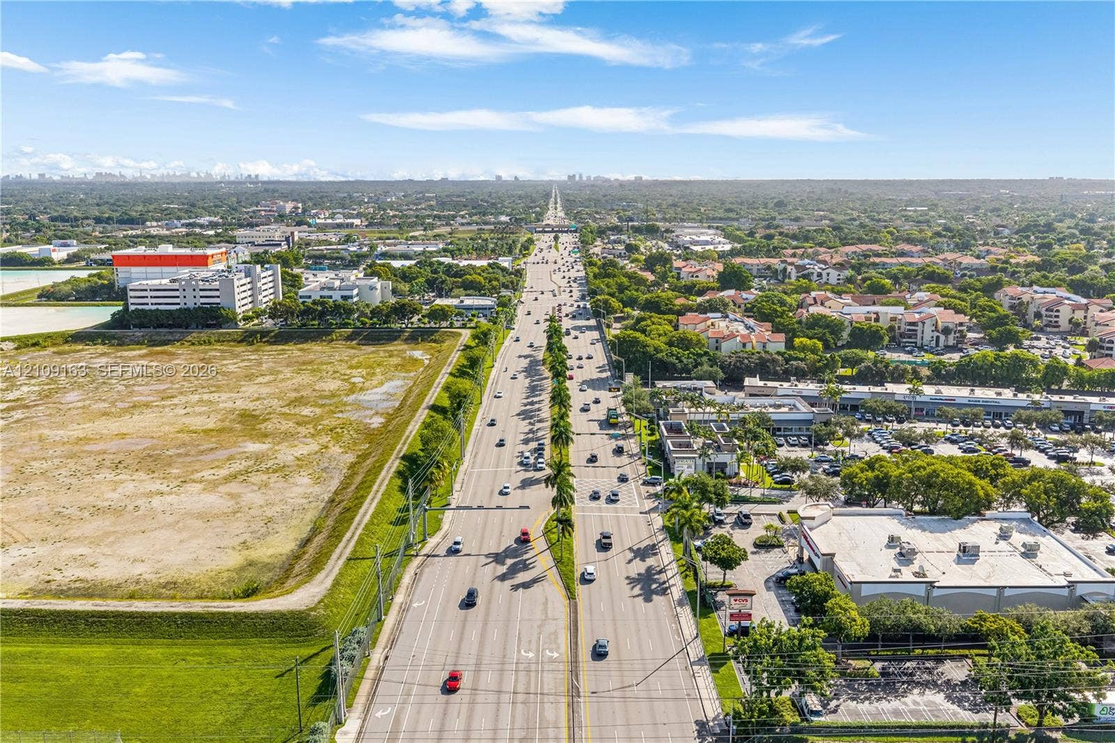 9122 SW 127th Avenue, Miami, FL 33186 Aerial view of multi-lane thoroughfare flanked by commercial developments, surface parking lots, and open green space