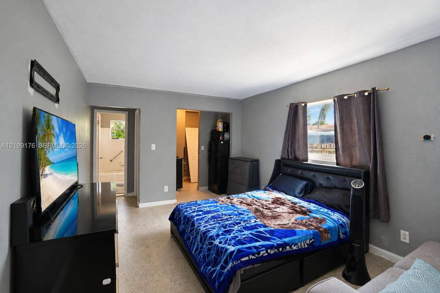 Interior space featuring neutral wall tones, uniform speckled flooring, a single-pane window, and recessed entryways