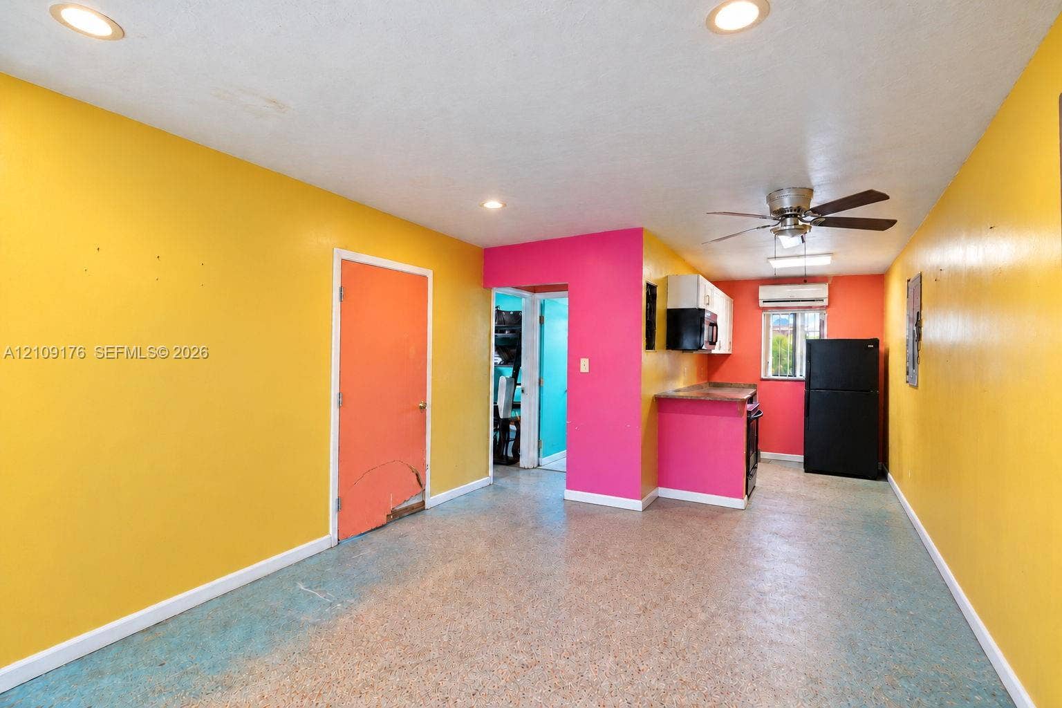 Kitchen area featuring recessed ceiling lighting, a ceiling fan, a wall-mounted climate control unit, and stone-finish flooring