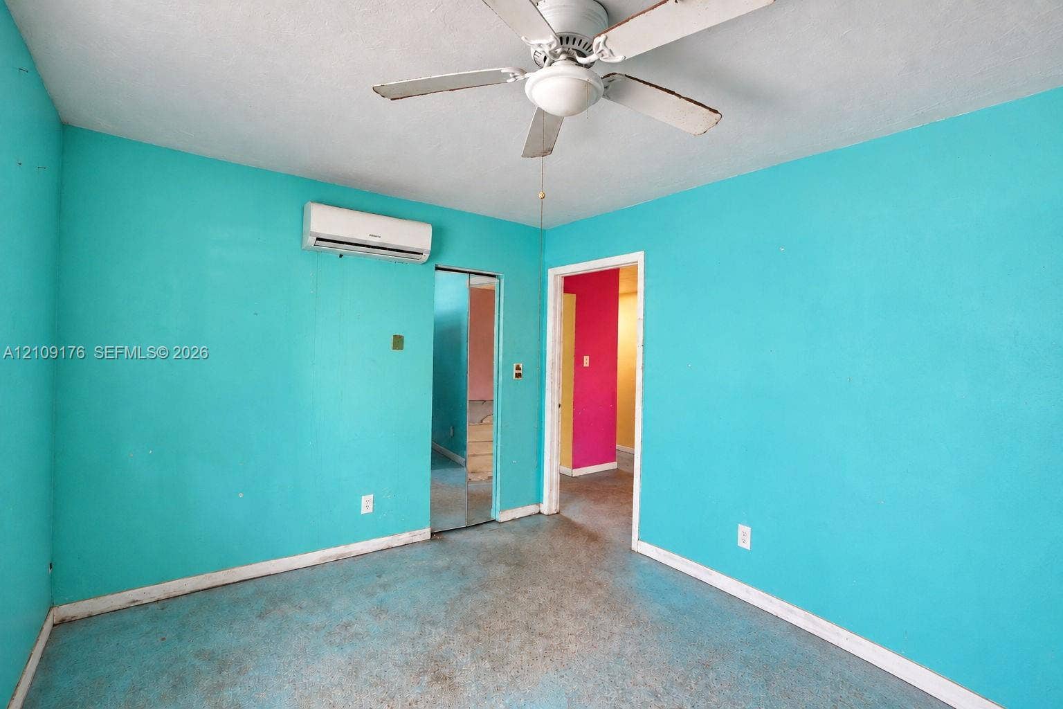 Wall-mounted ductless air conditioning unit, ceiling fan with integrated lighting, and mirrored closet doors