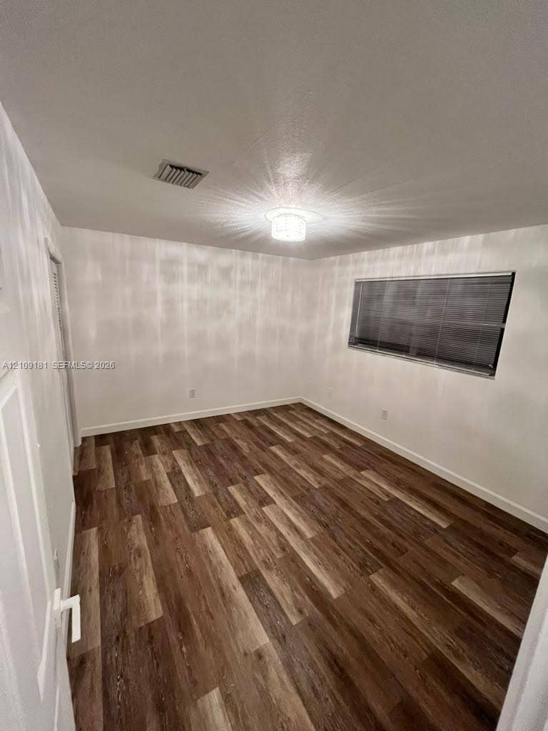 727 SW 10th Street, #1, Hallandale Beach, Hallandale Beach, FL 33009 Interior room featuring wood-finish flooring, a flush-mount ceiling light fixture, and horizontal window blinds