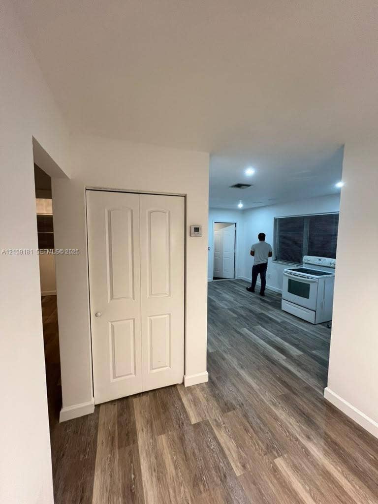 727 SW 10th Street, #1, Hallandale Beach, Hallandale Beach, FL 33009 Wood-finish flooring throughout, white bi-fold closet doors, recessed ceiling lighting, and a freestanding white range