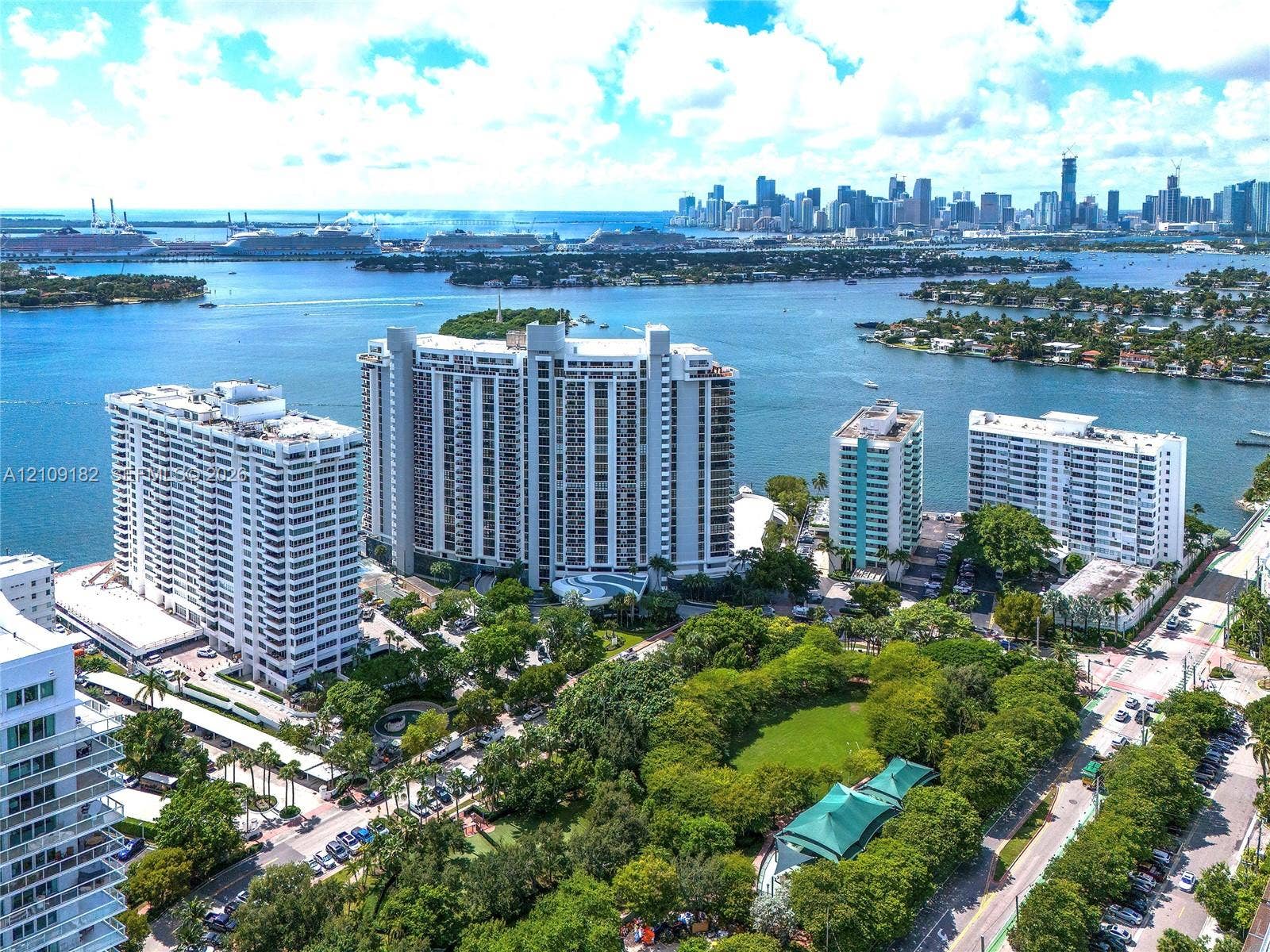 Aerial perspective showcasing high-rise coastal residential structures, mature landscaping, and proximity to the waterfront and urban center