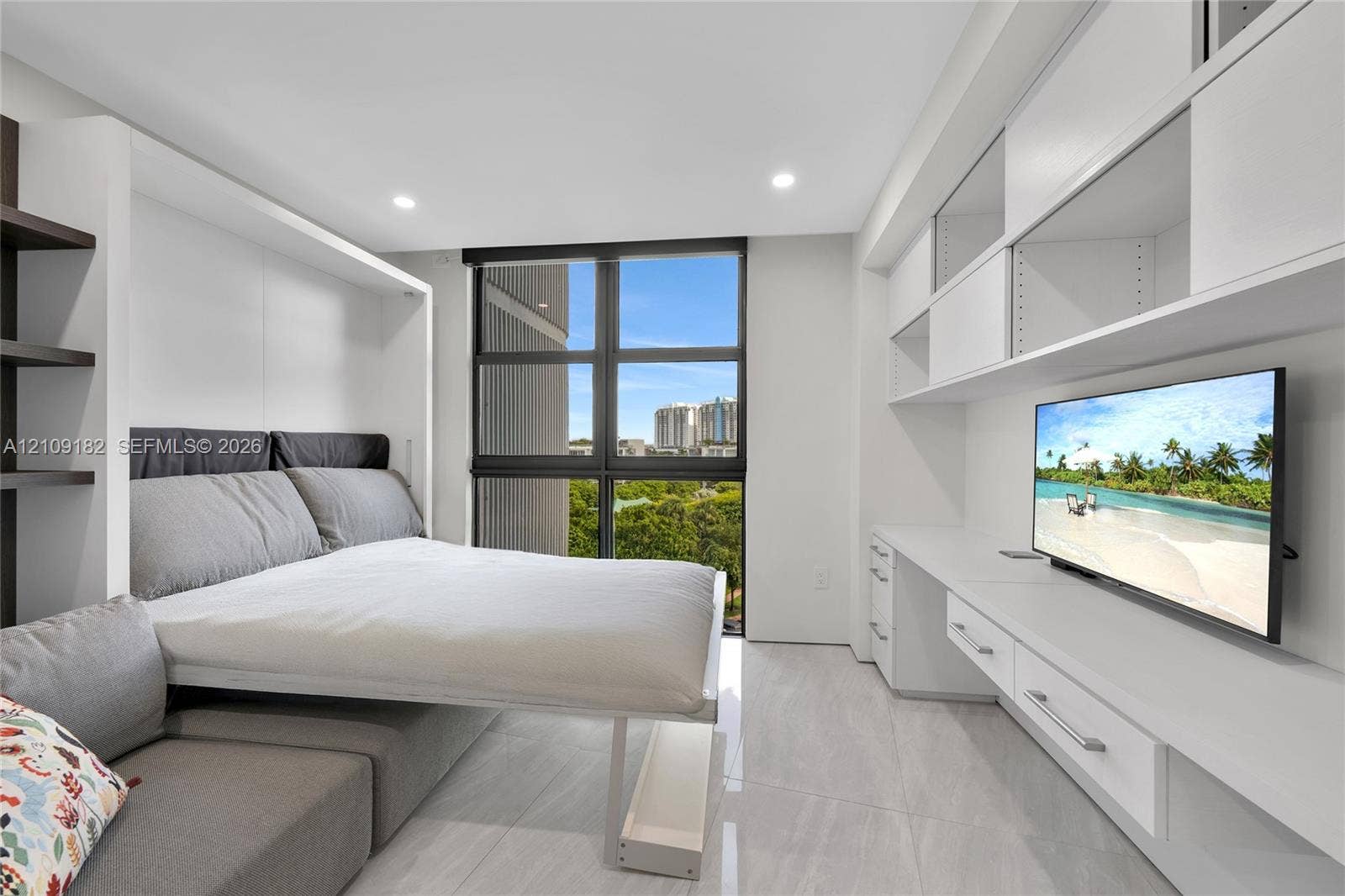 Built-in white cabinetry with integrated desk space and shelving, high-gloss floor tile, and large-format windows with structural mullions