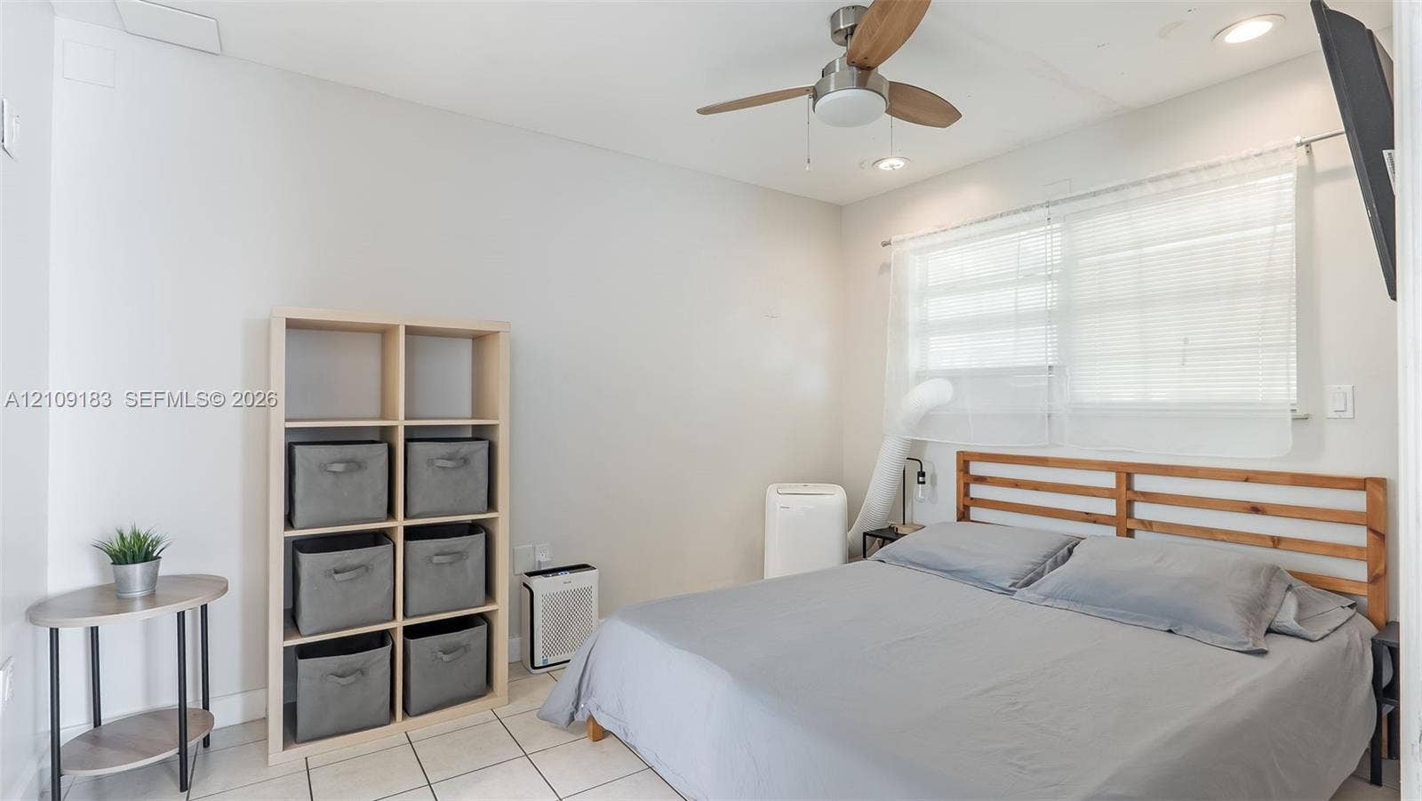 1009 NE 17th Court, Fort Lauderdale, FL 33305 Neutral-toned walls paired with large-format floor tile, recessed lighting, and a modern ceiling fan with wood-finish blades