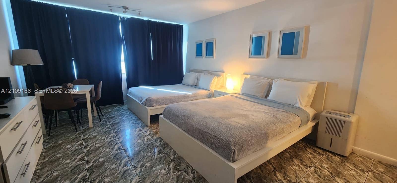 Spacious interior featuring patterned tile flooring and ceiling-mounted track lighting