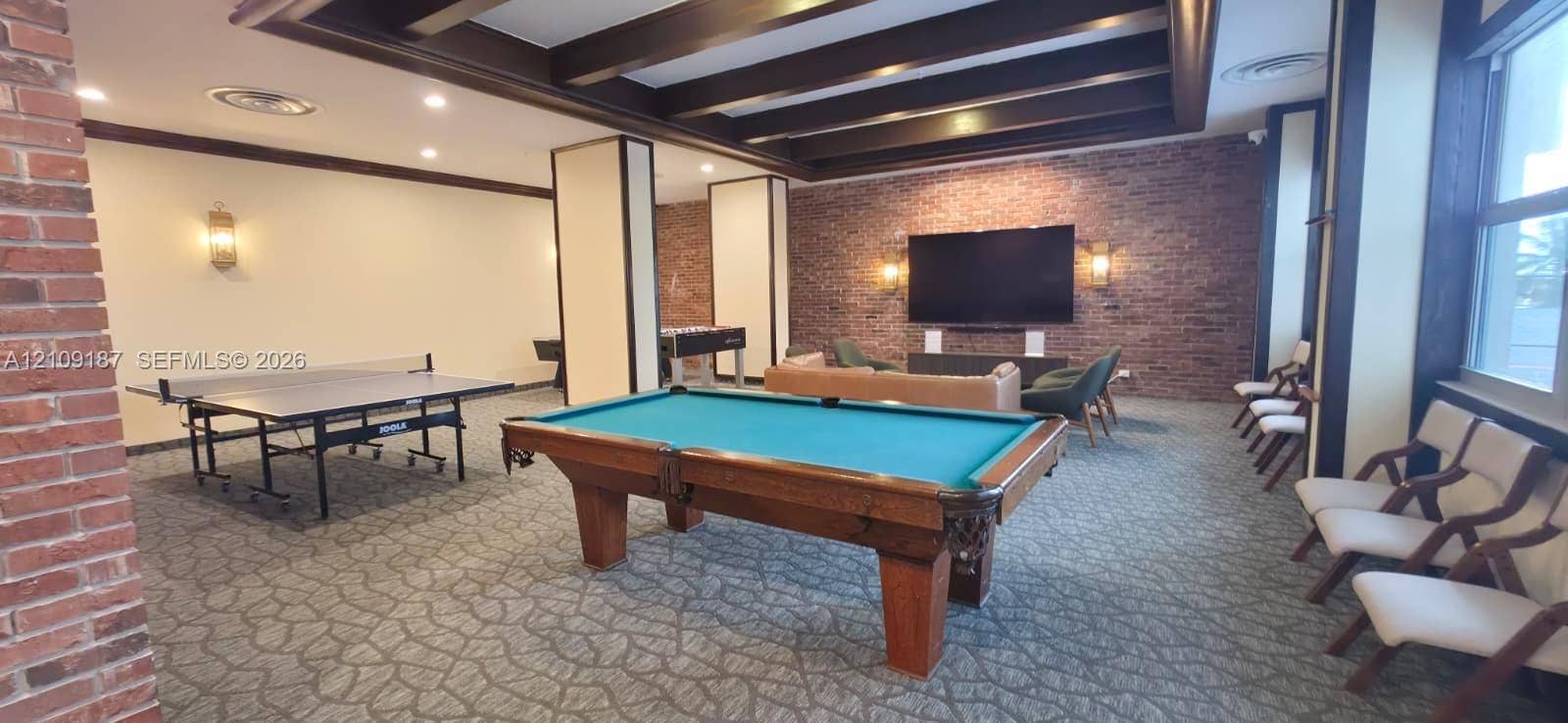6039 Collins Avenue, #1625, Miami Beach, FL 33140 Common area featuring exposed brick walls, exposed wooden ceiling beams, recessed lighting, and large windows