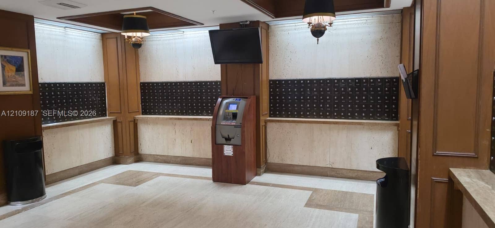 6039 Collins Avenue, #1625, Miami Beach, FL 33140 Mailboxes area featuring stone wall paneling, full-height wood millwork, pendant lighting, marble flooring and convenient ATM.