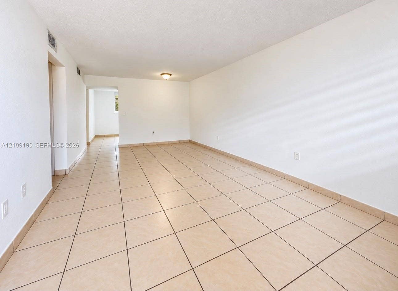 Neutral-toned ceramic tile flooring, smooth wall finishes, and flush-mount ceiling lighting