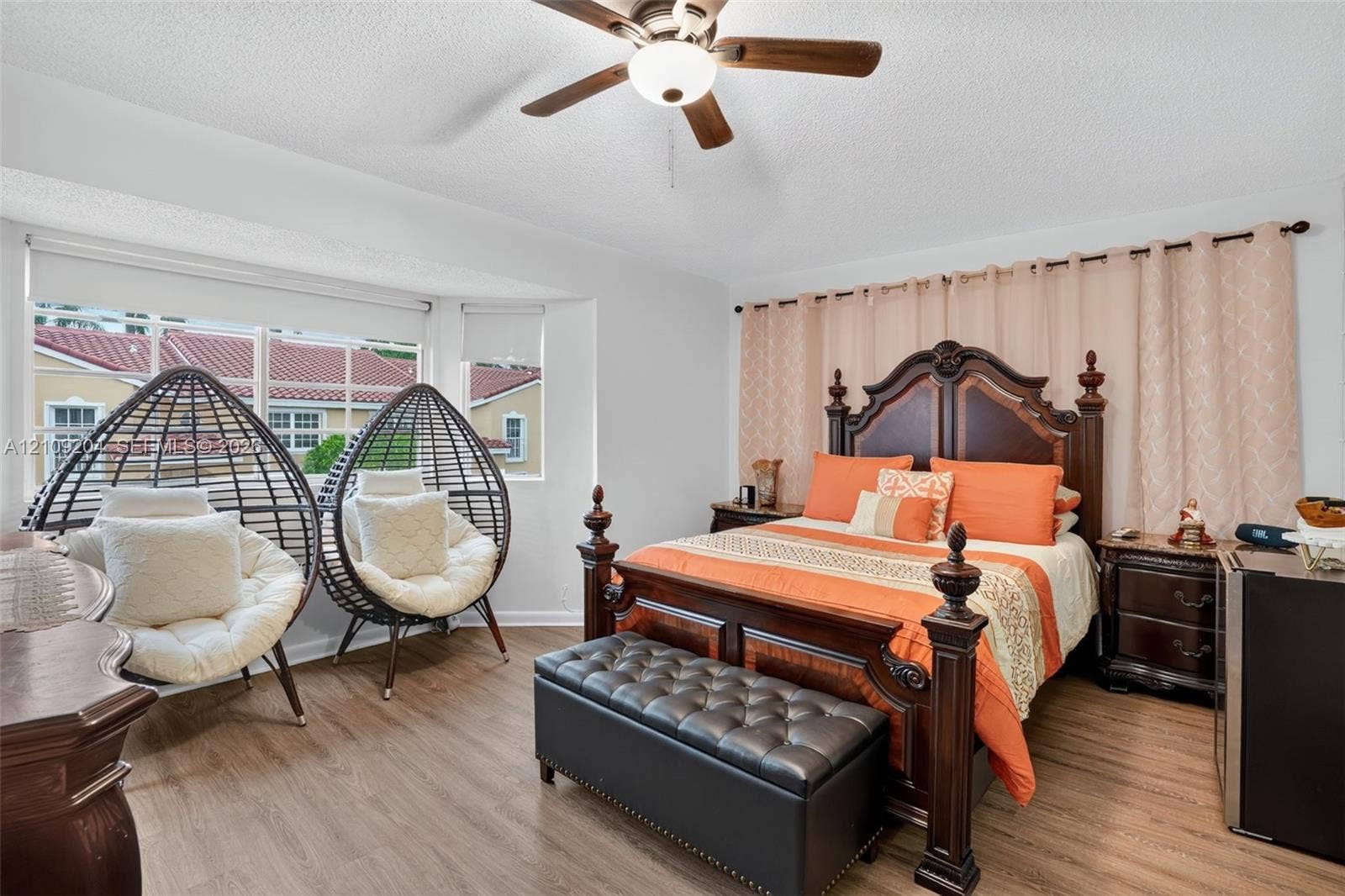 Wood-finish flooring, multi-pane bay window, and ceiling fan with integrated lighting